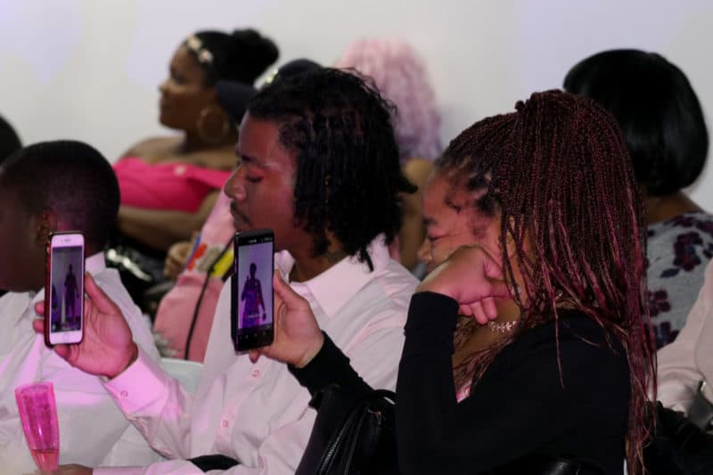 BROOKLYN, NY 10/28/18 2ND ANNUAL POWER IN PINK FASHION SHOW: Audience members capture Janelle Foster-Collins' speech on their cellphones. Photo by Babee Garcia